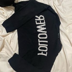 Black cropped sweater that has white writing on it